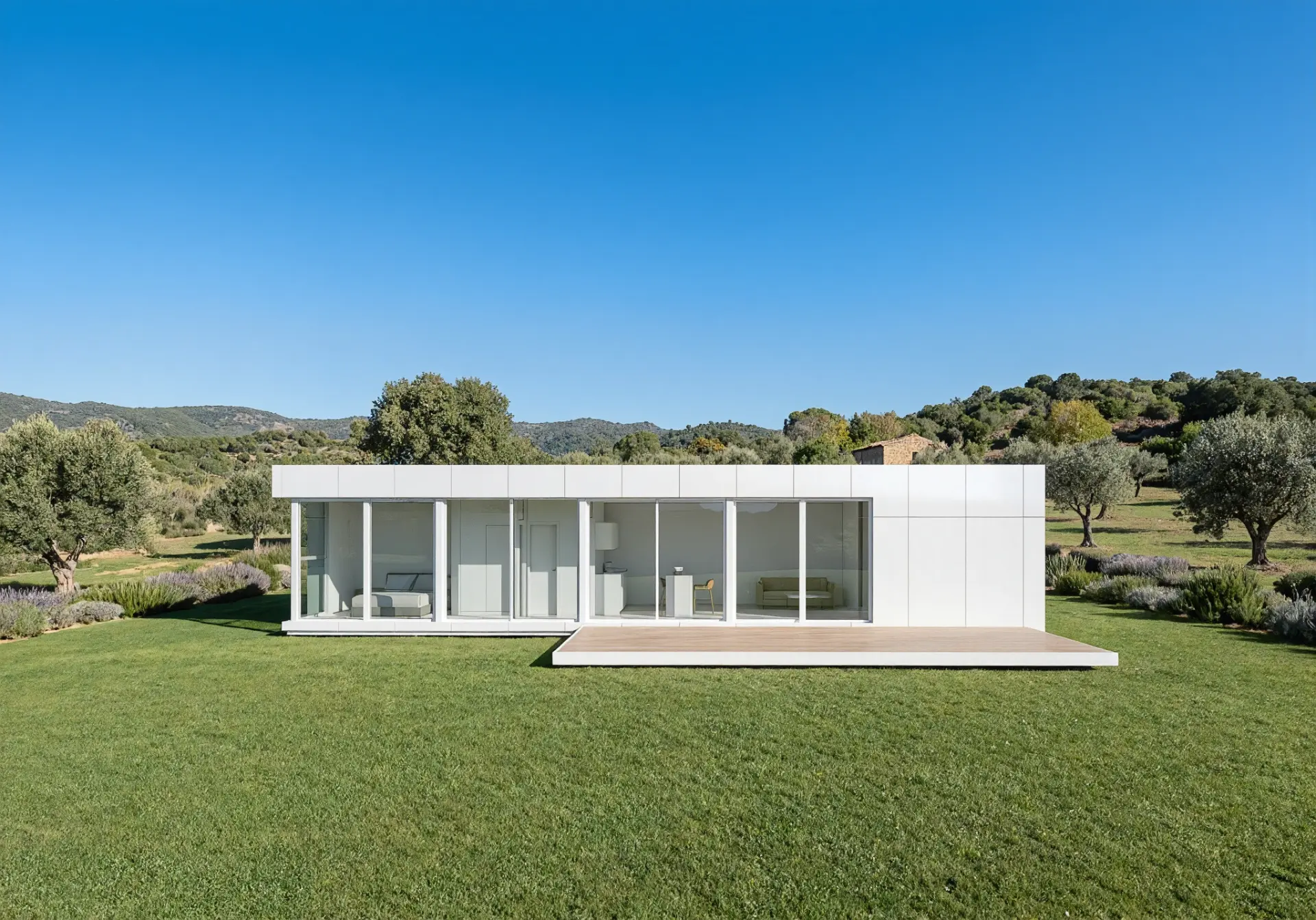 Modelo L de 3E HOUSES visto de frente: dormitorio, cocina con isla y salón tras la fachada acristalada, sobre una pradera con olivos